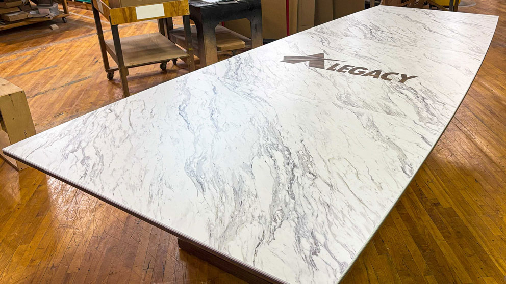 Custom conference table with logo in Thinscape laminate surface during fabrication